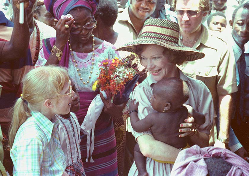 Photo of Mrs. Carter holds a baby while Amy Carter looks on in Lagos, Nigeria, in 1978.