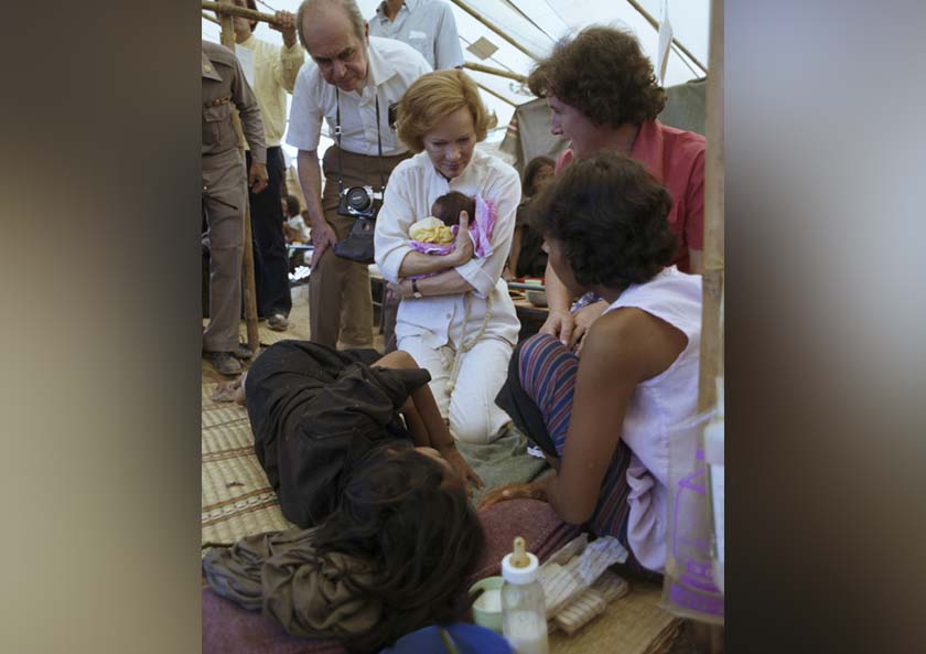 Photo of Rosalynn Carter holding a child at a Cambodian refugee camp in Thailand,1979.